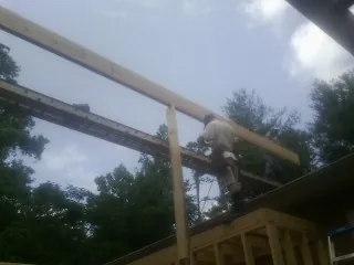 Carpenter setting a ridge beam over a new addition frame — Ice Dam Removal by Roofing Brothers in Mullan