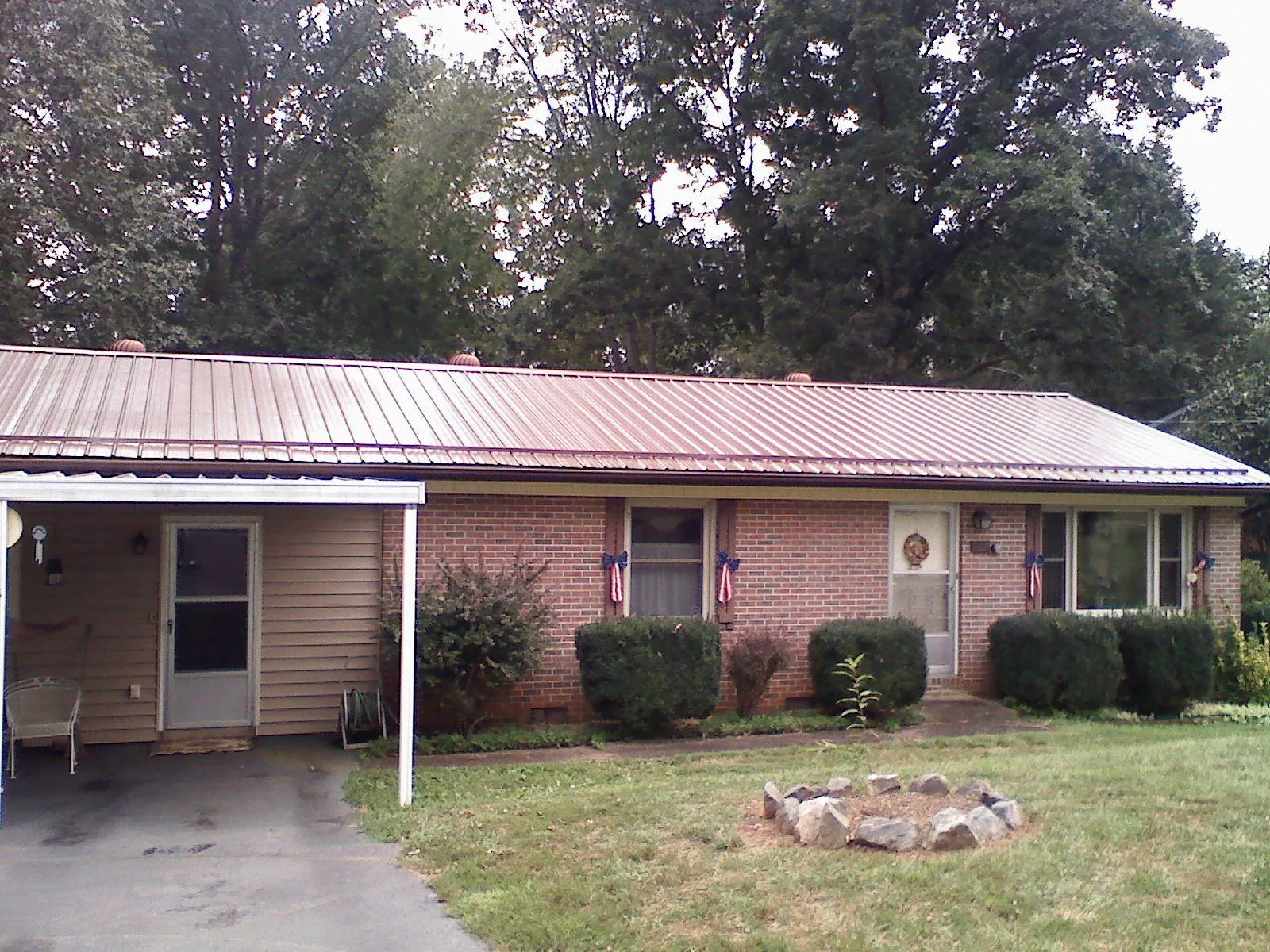 Bronze metal roof and carport on a brick ranch home — Roof Repair work by our crew in Mullan